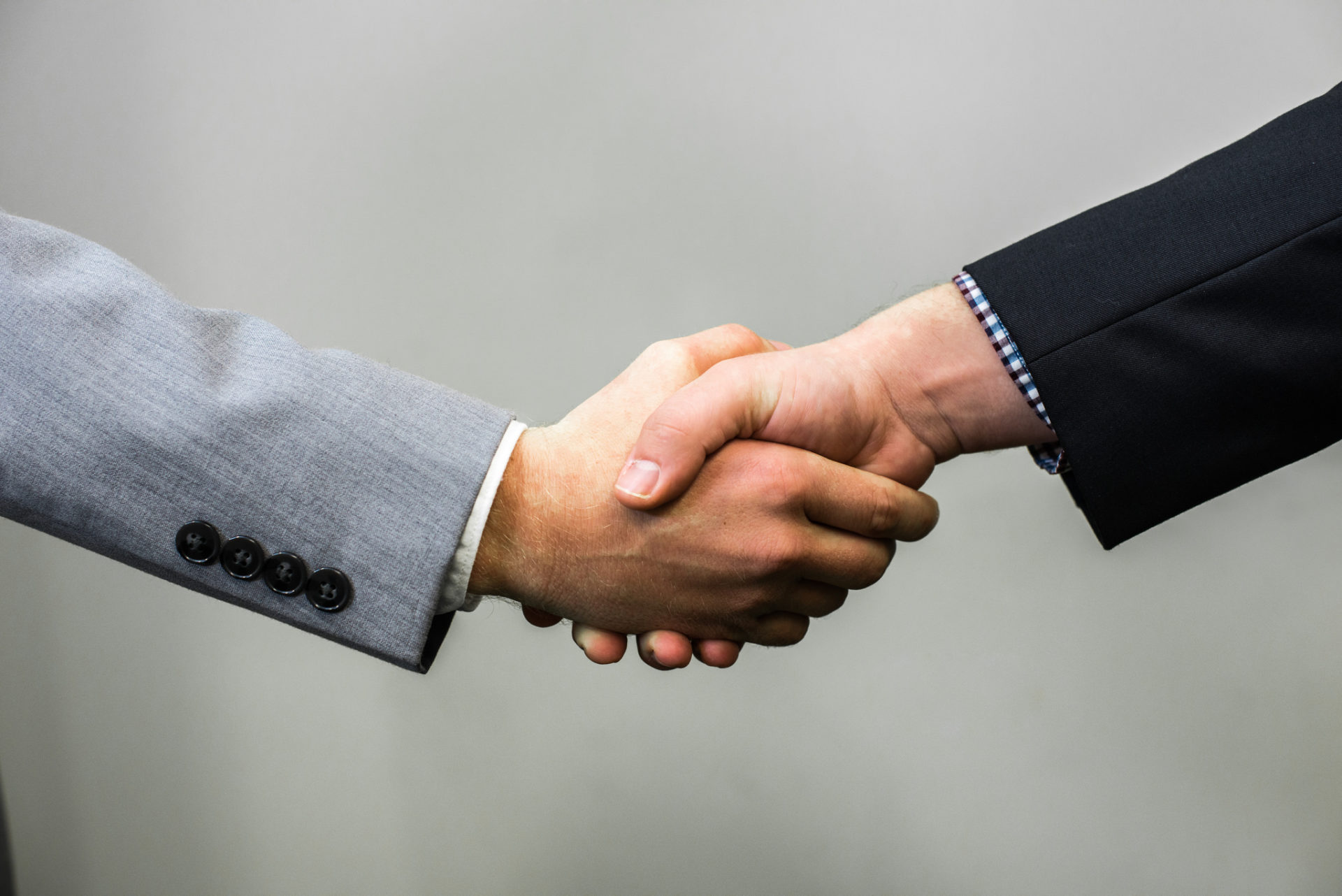 Close up of two men shaking hands.