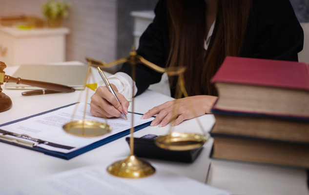 Paralegal working on the desk beside decorative scales