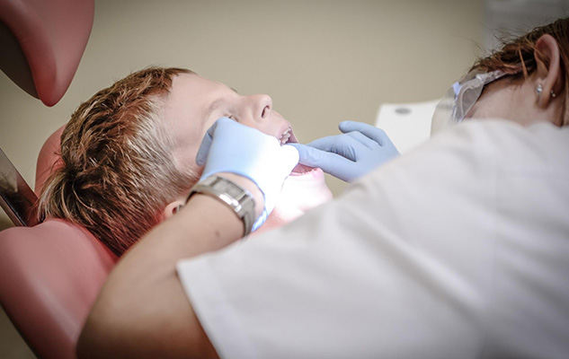 A close up of a child being treated by a dental assistant 