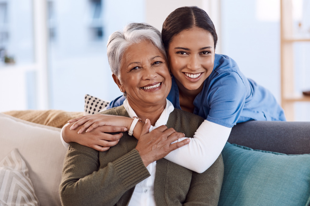 A nurse hugging an older person