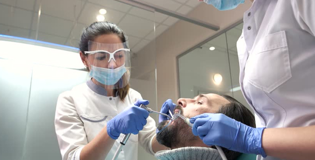  Dentist being assisted by a dental assistant