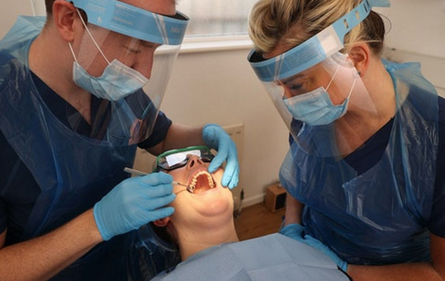 A dental assistant at work, helping a dentist