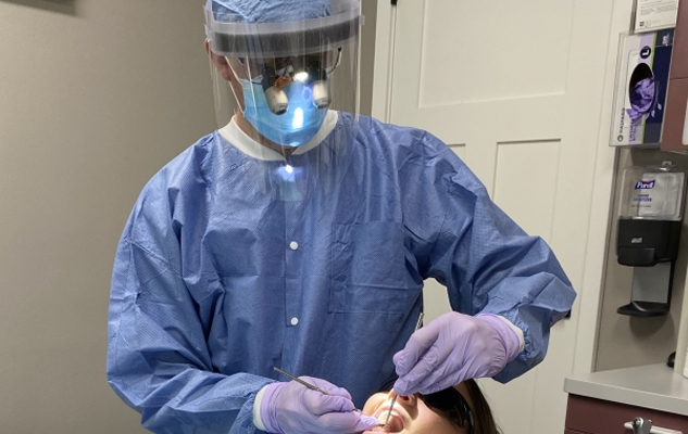 Dentist and dental assistant tending to a young patient