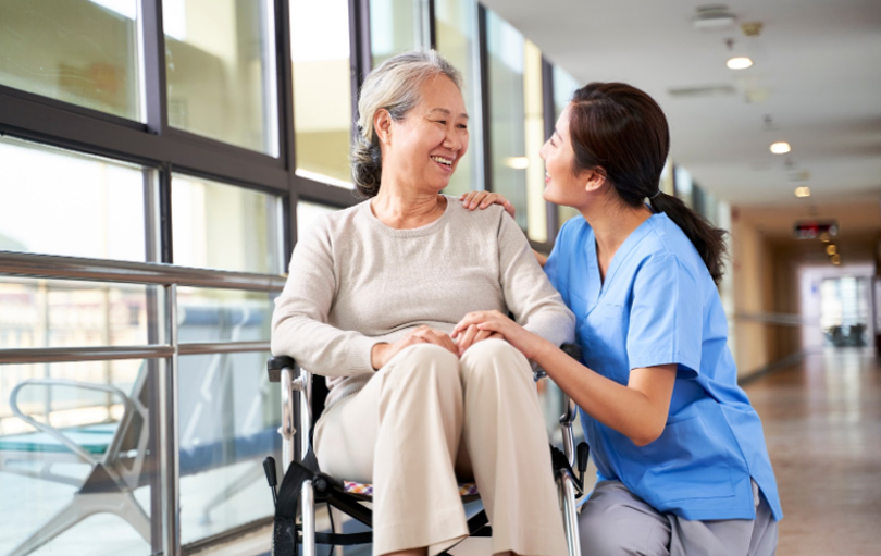 Personal support worker in a nursing home talking to a resident