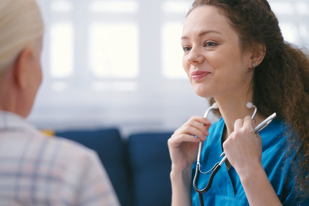 A person in blue scrubs holding a stethoscope