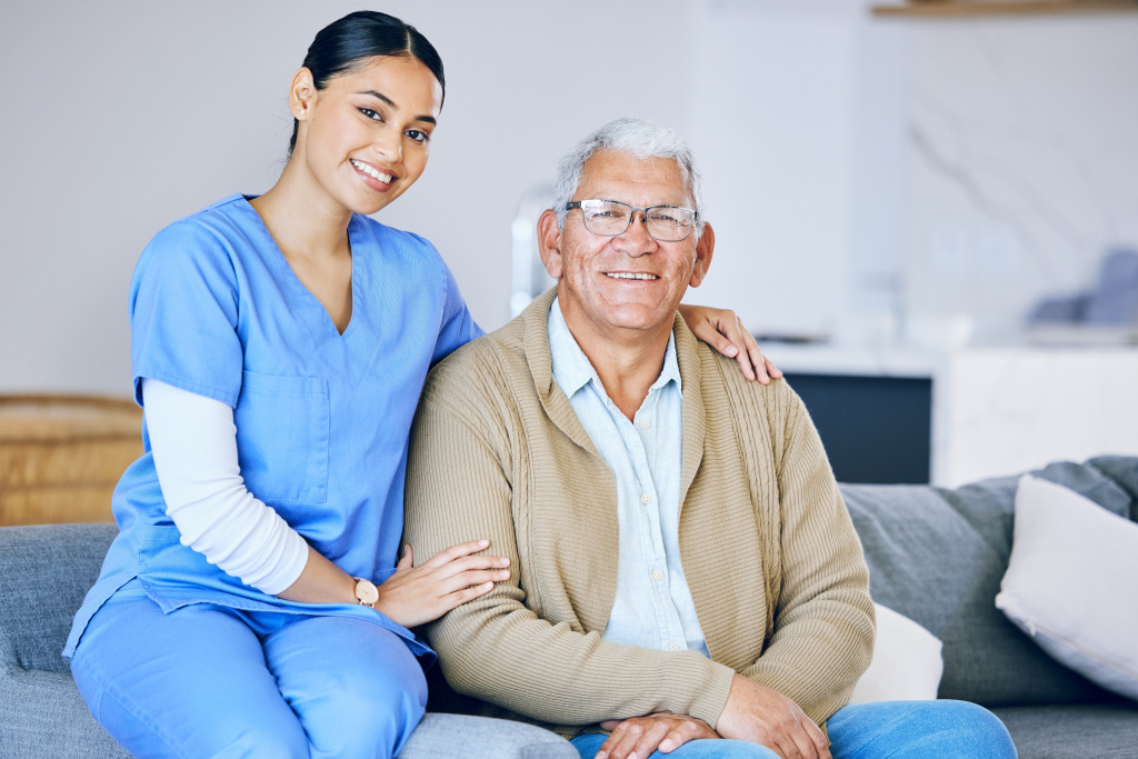 A person in blue scrubs sitting near another person