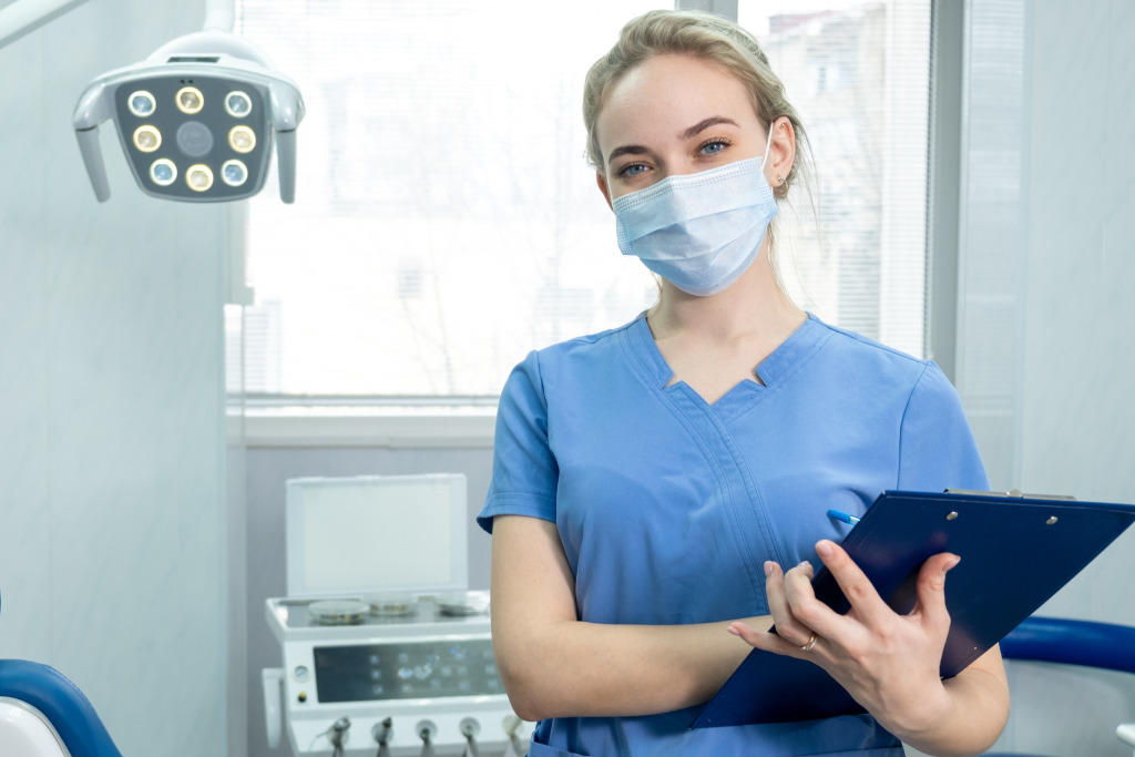 A person wearing a mask and holding a clipboard