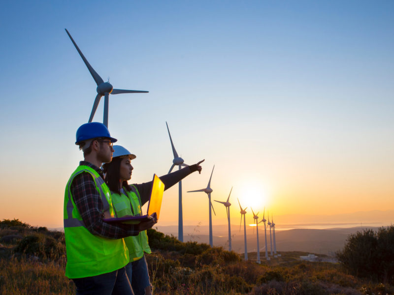 Young,Maintenance,Engineer,Team,Working,In,Wind,Turbine,Farm,At